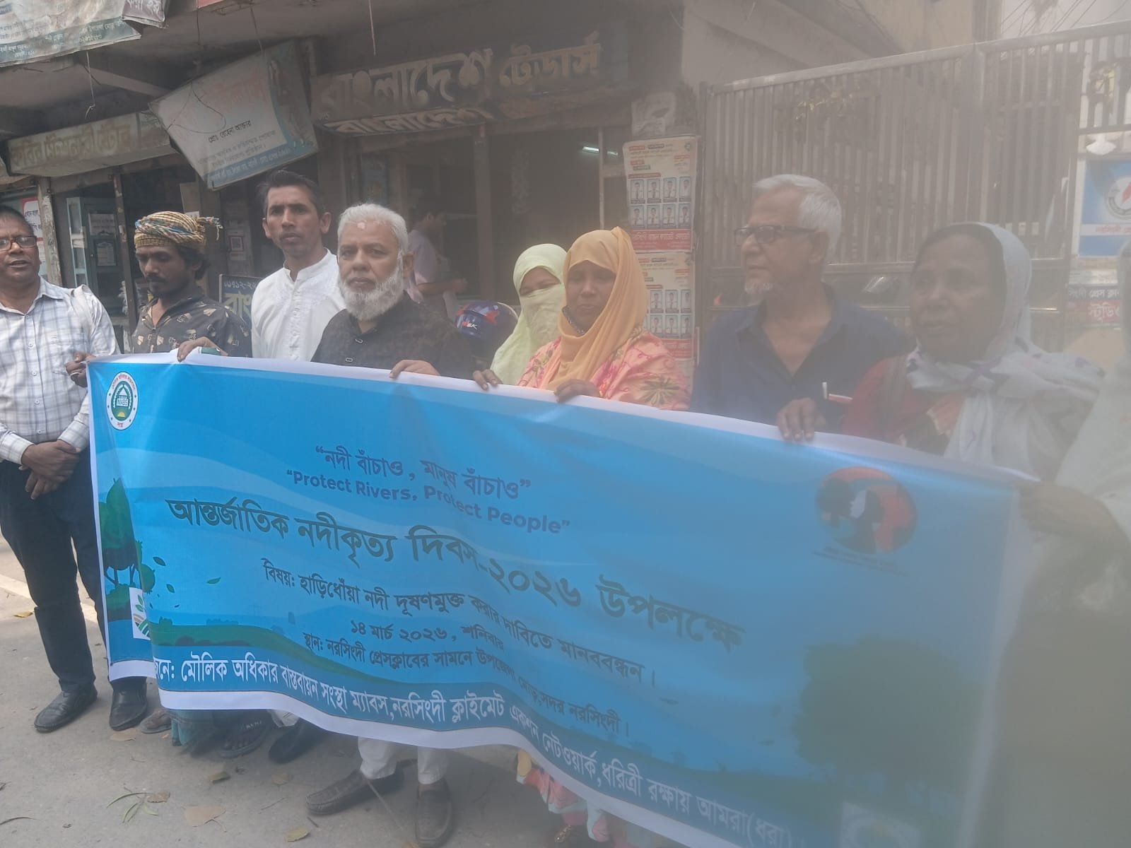 Outdoor awareness event with a banner, women present.